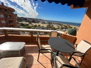 balcón con mesa y sillas y vistas a la playa en Mirador de Sanlucar 6, en Sanlúcar de Barrameda