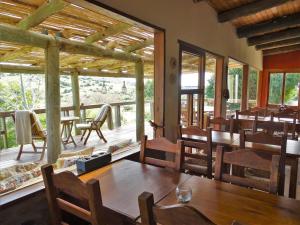 a dining room with tables and chairs on a deck at Valle del Hilo de la Vida in Minas