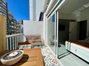 Habitación con balcón, cama y bañera. en Depto Las Heras en Mar del Plata