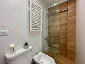 a bathroom with a toilet and a glass shower at Depto Las Heras -tucasaenmdp in Mar del Plata
