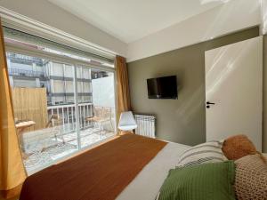 1 dormitorio con cama y ventana grande en Depto Las Heras en Mar del Plata