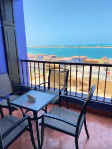a table and chairs on a balcony with a view of the beach at شاليه للإيجار في بورتو مارينا الساحل الشمالي العلمين 34 in El Alamein