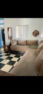 a living room with a couch and a checkered floor at Chez Housna in Rabat