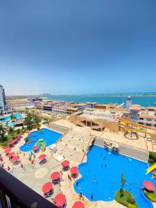 a view of a resort with two pools and umbrellas at شاليه للإيجار في بورتو مارينا الساحل الشمالي العلمين 34 in El Alamein