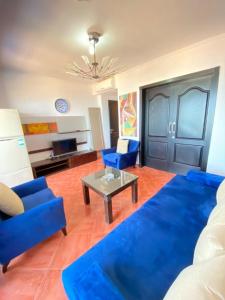 Sala de estar con sofás azules y mesa de centro en شاليه للإيجار في بورتو مارينا الساحل الشمالي العلمين 34, en El Alamein