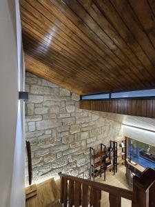 a room with a stone wall and a wooden ceiling at ON THE WAY - Mindelo Beach/Guest House in Mindelo