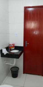 uma porta vermelha numa casa de banho com WC em Casa Mobiliada Nova em Petrolina em Petrolina