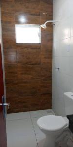 baño con aseo y puerta de madera en Casa Mobiliada Nova em Petrolina en Petrolina