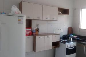 La cuisine est équipée de placards blancs et d'un réfrigérateur blanc. dans l'établissement Casa Mobiliada Nova em Petrolina, à Petrolina