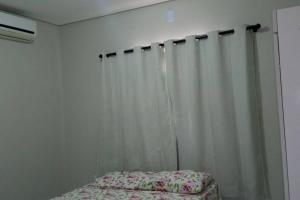 Casa Mobiliada Nova em Petrolina في بترولينا: غرفة نوم وستارة بيضاء وسرير
