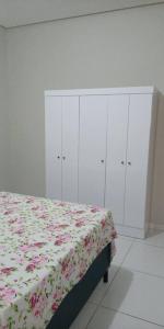 1 dormitorio con 1 cama con manta floral y armarios en Casa Mobiliada Nova em Petrolina en Petrolina