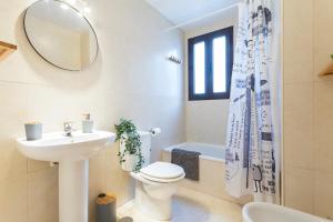 un bagno con lavandino, WC e specchio di Cruz Vieja Centrico 3 Rooms a Jerez de la Frontera