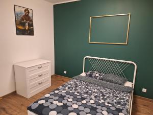 a bedroom with a bed and a green wall at Apartament Golda in Toruń