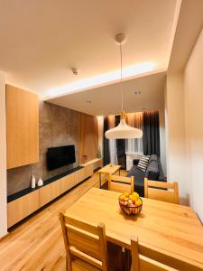 ein Esszimmer und ein Wohnzimmer mit einem Holztisch in der Unterkunft Apartment 202 - Aparthotel Zlatni Javor in Jahorina