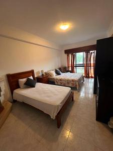 um quarto de hotel com duas camas e uma televisão em Happyhouse em Algueirão