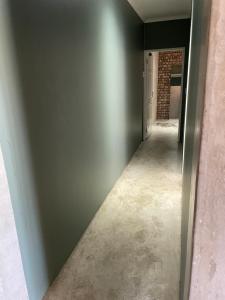 un pasillo vacío con una pared gris y una puerta en Vintage Corner Accomodation en Walvis Bay