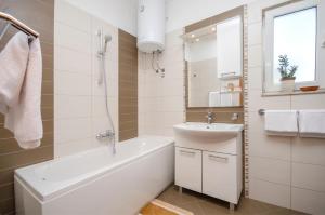 a white bathroom with a sink and a bath tub and a sink at Apartments Maris in Tribunj +39 photos