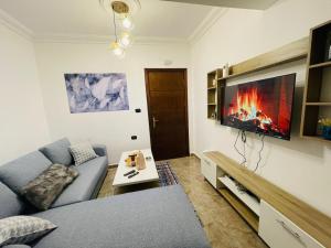 a living room with a couch and a fire on the wall at تلاع العلي in Amman