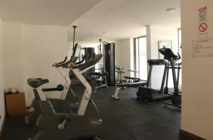 een fitnessruimte met diverse loopbanden en hometrainers bij Apartamento para 2 con gran Piscina in Santiago
