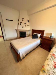 a bedroom with a large bed and a fireplace at Happyhouse in Algueirão - Mem Martins