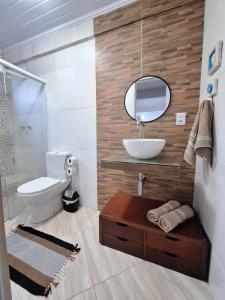 a bathroom with a sink and a toilet and a mirror at Casa da Manjuba in Angra dos Reis