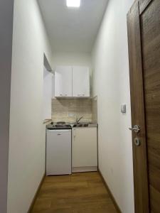 a small kitchen with a stove and white cabinets at Apartmani Dino Kolasin in Kolašin