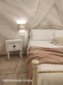 マテーラにあるLo splendore dei Sassiのベッドルーム(白いベッド1台、ナイトスタンド付)