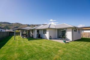 a house with a large yard with green grass at Alpha'N'est - Cromwell Holiday Home in Cromwell
