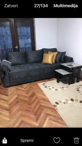 a living room with a black couch and a table at Milja Goč in Kraljevo
