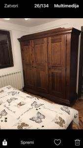 um quarto com uma cama e um armário de madeira em Milja Goč em Kraljevo