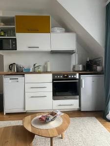 a kitchen with white cabinets and a table in a room at B-Apartment Vienna 12 in Vienna
