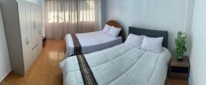 a bedroom with a large bed with white sheets at SAMAY Casa familiar en el valle sagrado in Calca