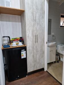 a kitchen with a black refrigerator and a sink at Ecos del Manantial in Villarrica