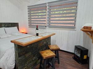 ein Schlafzimmer mit einer Badewanne und einer Flasche Wein in der Unterkunft Ecos del Manantial in Villarrica