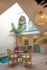 een patio met stoelen, een tafel en een zwembad bij Riad Chic in Marrakesh
