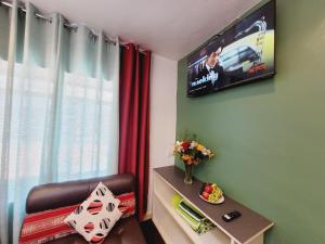 a room with a television on a wall with a chair at wayra house san blas in Cusco