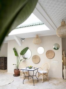 Cette chambre comprend une table, des chaises et des miroirs ronds. dans l'établissement Riad Chic, à Marrakech