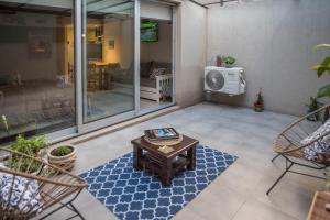 a patio with a table and chairs and a tv at El Patio Suites en Palermo Hollywood in Buenos Aires +38 photos