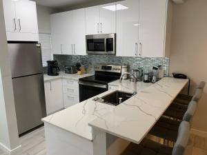 a kitchen with white cabinets and a counter top at Plantation Village # 64 Seven Mile Beach Fully Renovated Modern 2 Bed 2 Bath in George Town