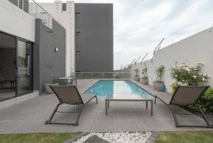 a patio with a pool and two chairs and a table at Tranquil Zen Oasis in Midrand: The Perfect Retreat in Midrand