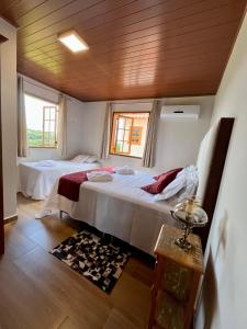 een slaapkamer met 2 bedden en een houten plafond bij Casa 2 Chalé Alto dos Bandeirantes-Tiradentes in Tiradentes
