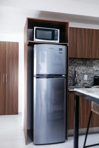 a kitchen with a stainless steel refrigerator and a microwave at Monyxbnb Hotel in Puerto Vallarta