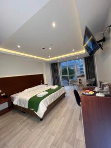 um quarto com uma cama, uma secretária e uma televisão em EL ALAMO, EJECUTIVO Y SPA em Cusco