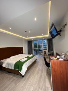 um quarto com uma cama, uma secretária e uma televisão em EL ALAMO, EJECUTIVO Y SPA em Cusco