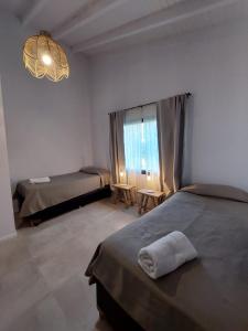 um quarto com 2 camas e uma grande janela em Al pie del Cerro em Villa La Angostura