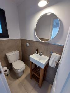 a bathroom with a toilet and a sink and a mirror at Al pie del Cerro in Villa La Angostura