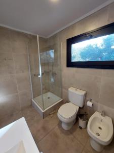 uma casa de banho com um WC, um chuveiro e um lavatório. em Al pie del Cerro em Villa La Angostura