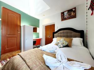 a bedroom with a bed with a white blanket at wayra house san blas in Cusco
