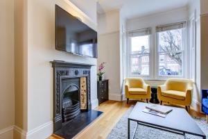 sala de estar con chimenea y TV en 4 Bedroom, large house, with private parking and just 23 minute train ride to Waterloo, en Raynes Park