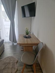 a living room with a wooden table and a chair at M&BLuxux Apartaments in Krefeld